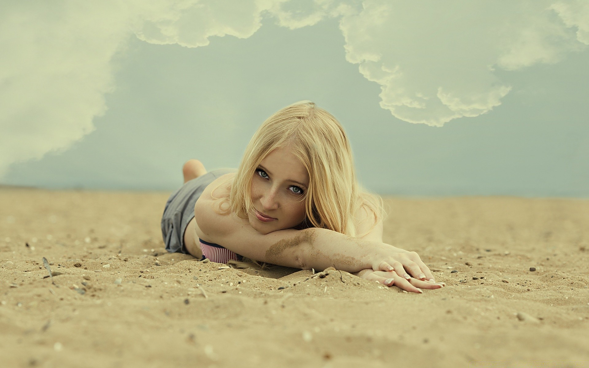 Красивая девушка позирует на песке