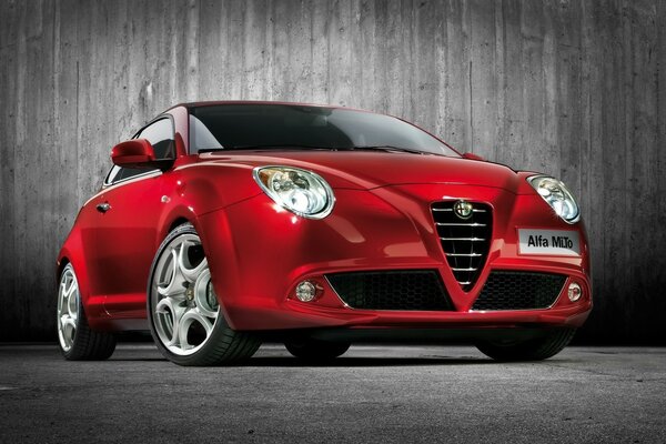 Красный автомобиль alfa romeo спереди на черном фоне