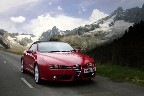 Das rote Auto ist ein alfa Romeo. Landschaft auf den Bergen