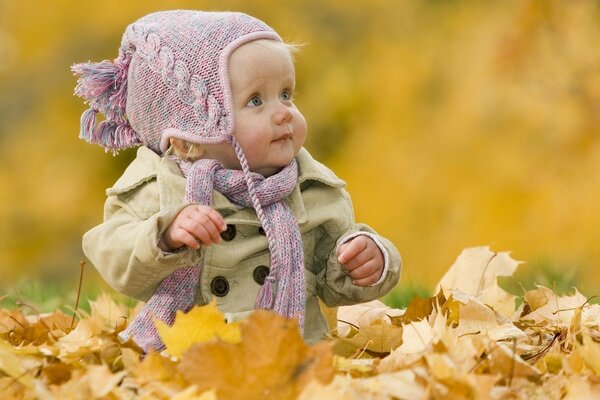 Enfant dans le parc joue avec des feuilles