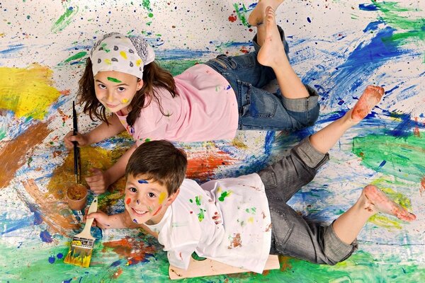 A boy and a girl are playing in paint