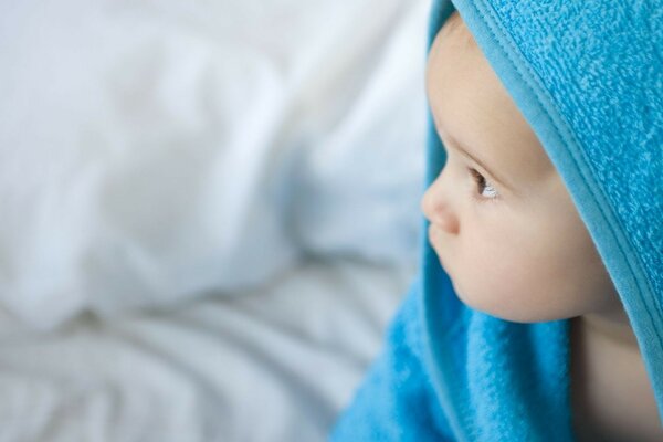 The face of a child in a blue cloth