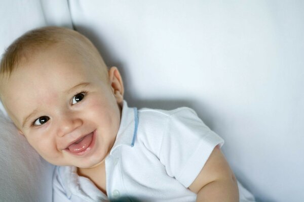 Bébé riant dans un t-shirt blanc