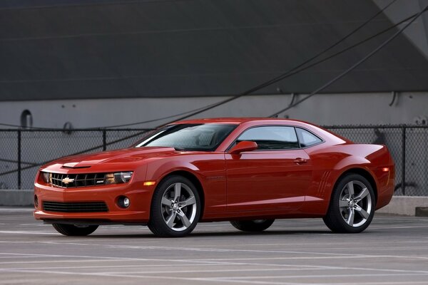 A red chevrolet rushes down the road