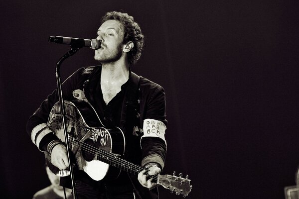 Concert photo of a musician with a guitar and microphone