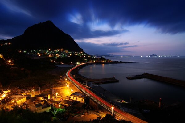 Strada notturna lungo il mare scuro