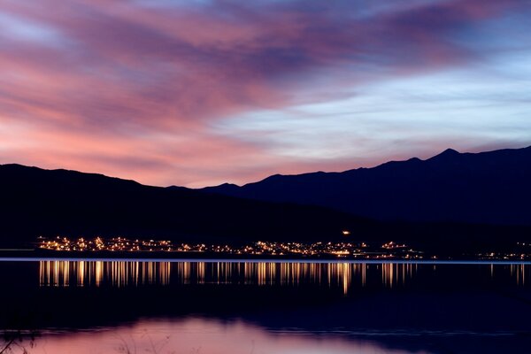 Côte dans les lumières au coucher du soleil se reflète dans les eaux côtières