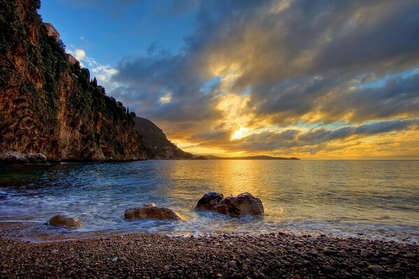 Coucher de soleil sur le bord de mer rocheux de l arbre