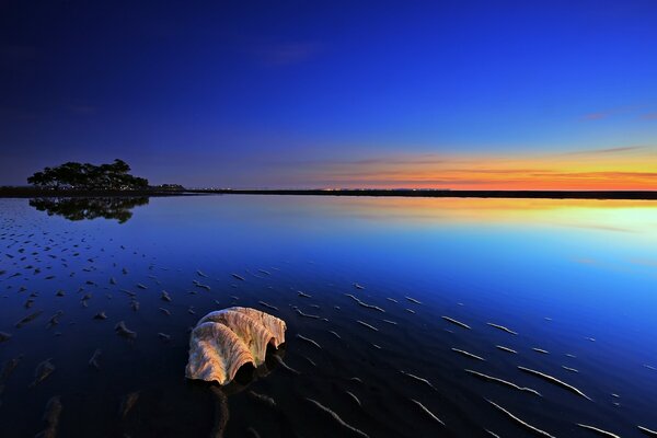 Sunset creeps over static water