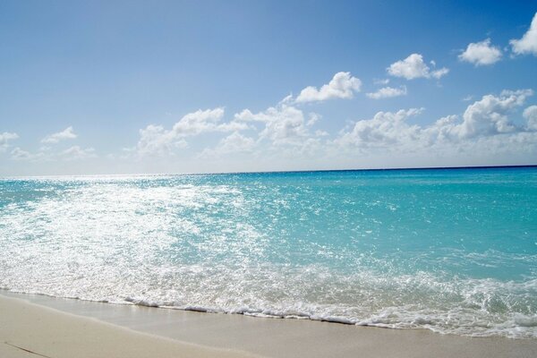 Песочный пляж у голубого моря
