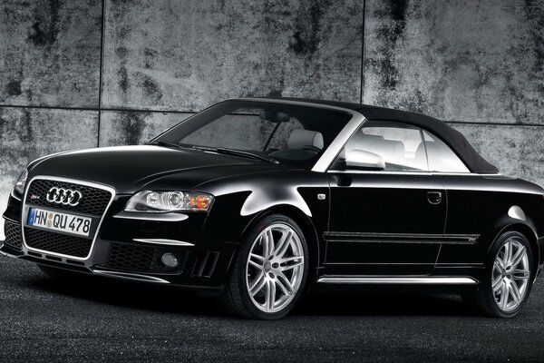 Black Audi car on the background of a concrete wall