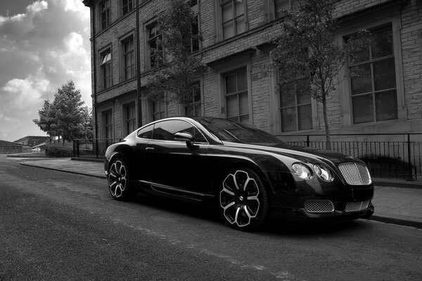 The Bentley is parked at the curb