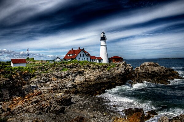 Farol branco na costa rochosa