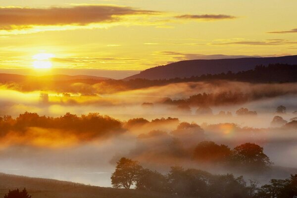 Amanecer ardiente por encima de las nubes con neblina traviesa