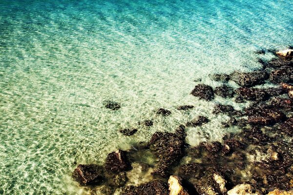 Sunny beach of the sea with stones