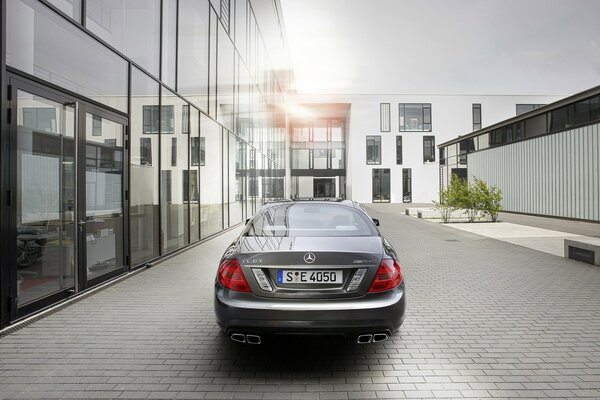 Mercedes car on a gray background near a glass building