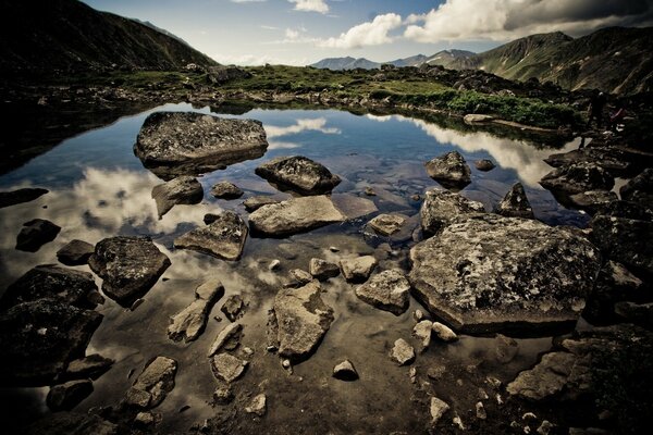 Paisaje de piedras en el agua con un cielo reflectante