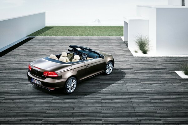 A brown-colored convertible in the courtyard of the house