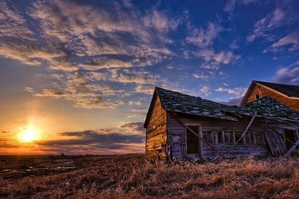 Puesta de sol en medio de nubes cirros y edificios abandonados