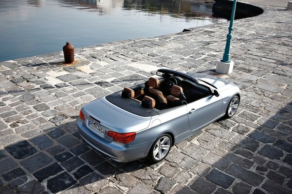 Silver convertible near the city reservoir