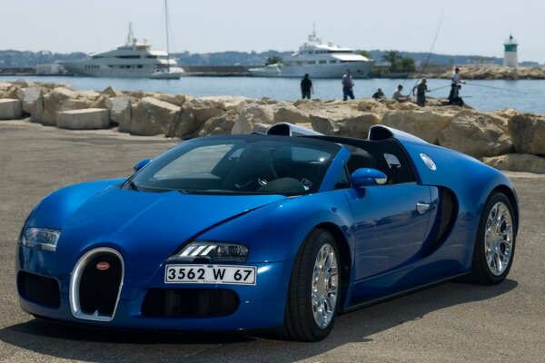 Blauer Bugatti am Meer am Strand