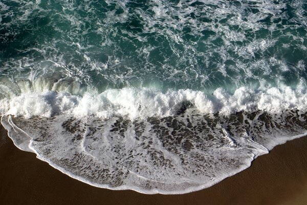 Mousse et vagues qui s écrasent sur le rivage