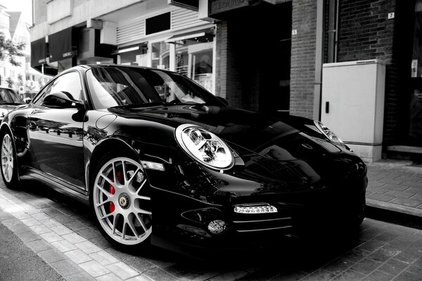 A dazzling black Porsche on a city street