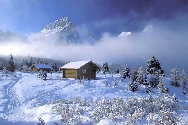 Hütte im Schnee auf dem Hintergrund der Berge