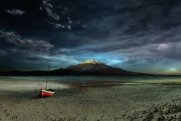 Beach with a lonely boat at sunset