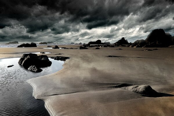 Verlassener Strand vor dem Hintergrund dunkler Wolken