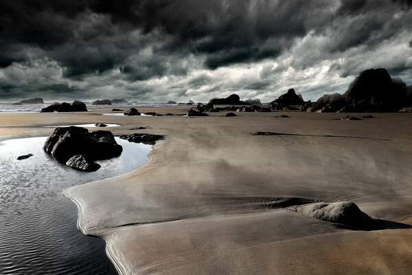 A deserted beach against the background of dark clouds