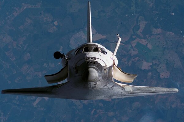 Transbordador espacial en el fondo de la superficie de la tierra