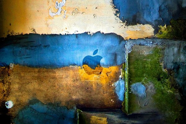 The apple symbol on the background of a dirty multicolored wall