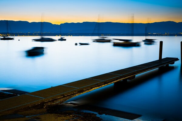 Río. Pasarela. Barcos en el agua. Fondo borroso