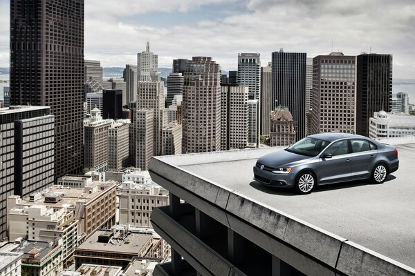 A black car is standing on the edge of the roof