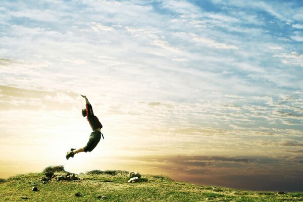 Jumping guy on the background of the sky with clouds