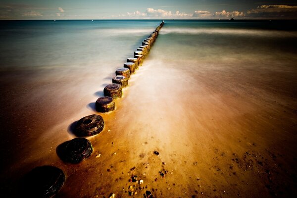 Rangée de pierres sur le sable humide