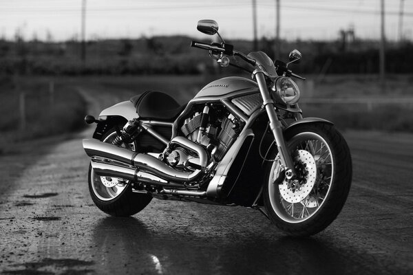 Foto en blanco y negro de una motocicleta en una carretera vacía