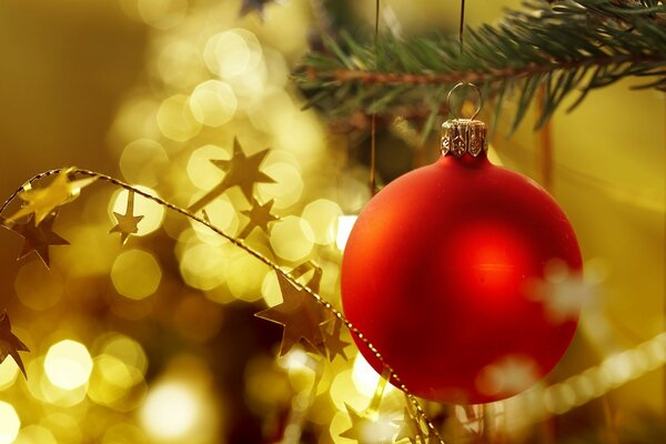 Foto borrada brinquedo de bola de Natal vermelho em fundo de ouro