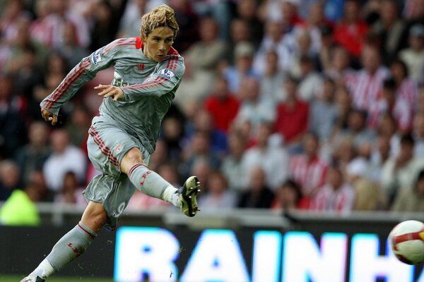 A football player in motion hits the ball