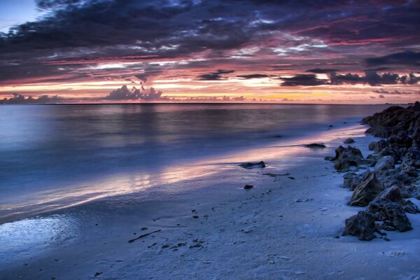 Sandy deserted beach on the background of a bright sunset