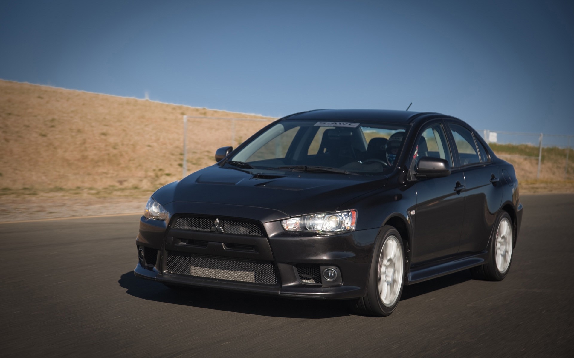 mitsubishi car vehicle blacktop noon hurry asphalt pavement transportation system automotive hood wheel sedan travel action mitsubishi lancer evolution