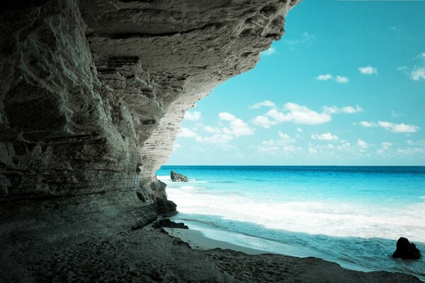 Grotte dans le rocher au bord de la mer