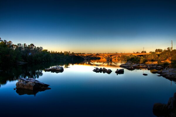 Ein stiller Spiegelsee im Morgengrauen