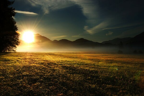 Amanecer en medio de montañas y campos