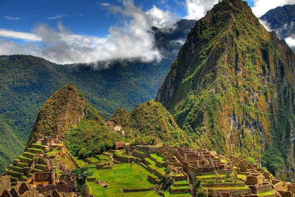 Ancient Mayan buildings on the background of mountains and sky