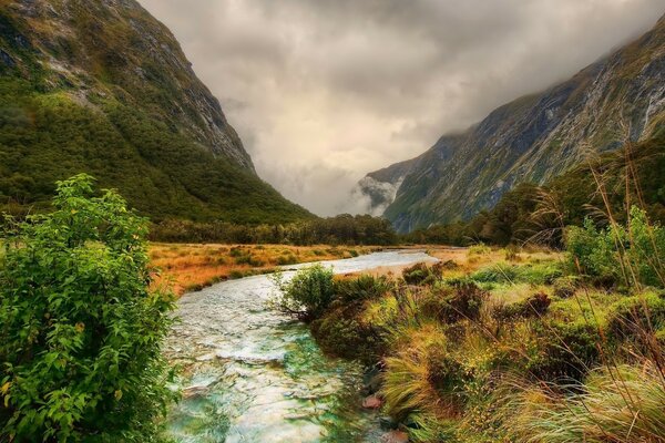 River on the background of mountains and gray clouds