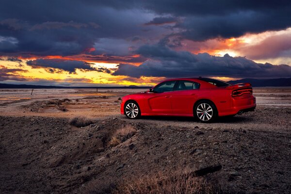 Rotes Auto fährt in den Sonnenuntergang