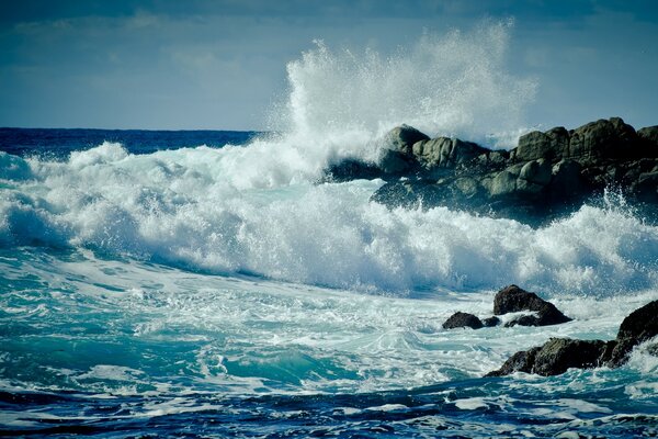 The raging ocean hits the waves on the rocks