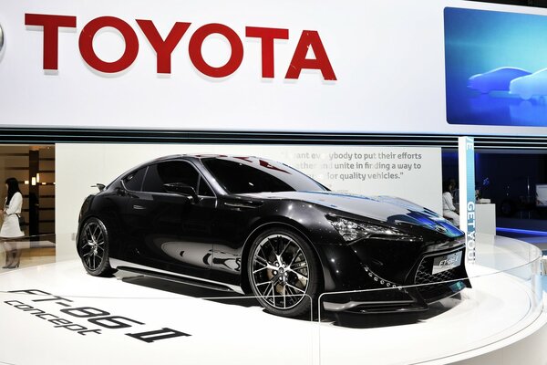 New black Toyota on a white podium